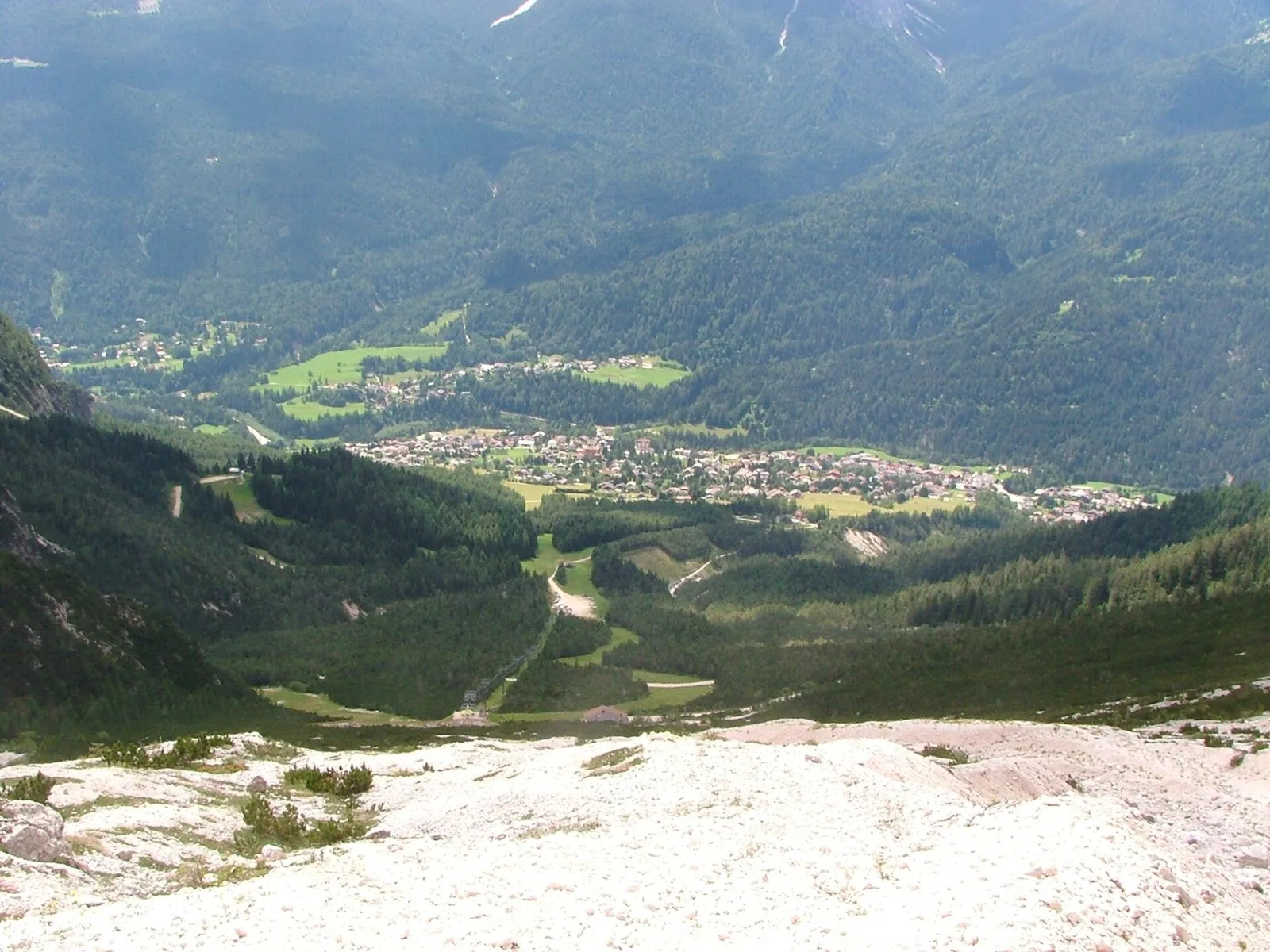 Veduta dall'alto di San Vito di Cadore nella conca verde della Val del Boite, circondata da boschi